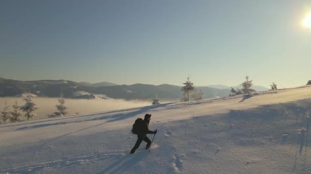寒冷冬日背着背包在雪山山坡上散步的徒步旅行者 — 图库视频影像
