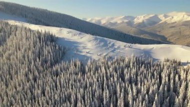 Soğuk, aydınlık bir günde şiddetli kar yağışı sonrası dağ tepeleri ile kaplı, kışın hava manzarası..