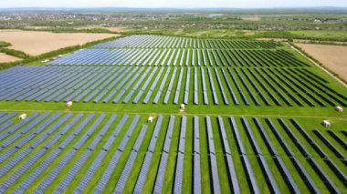 Temiz ekolojik elektrik enerjisi üretmek için birçok sıra güneş fotovoltaik paneli bulunan sürdürülebilir büyük elektrik santralinin havadan görünüşü. Sıfır emisyon kavramı ile yenilenebilir elektrik.