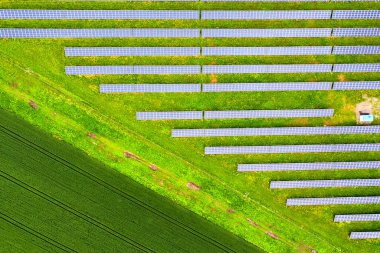Yeşil alandaki güneş enerjisi santralinin havadan görüntüsü. Temiz ekolojik enerji üretmek için elektrik panelleri.