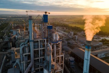 Yüksek beton fabrikası ve endüstriyel üretim alanında kule vinci olan çimento fabrikasının havadan görüntüsü. Üretim ve küresel sanayi kavramı.