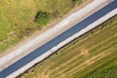 Yeni döşenmiş asfalt şeritli yeni yol yapımının havadan görünüşü.