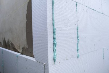 Termal koruma için ev cephesi duvarına köpük yalıtım çarşafları kurulumu.