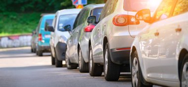 Sokak kenarında park halindeki arabalarla şehir trafiği.