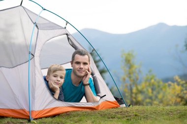 Küçük babası ve küçük oğlu yaz dağlarında birlikte yürüyüş yapıyor. Aktif aile seyahati kavramı.