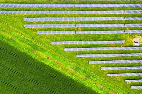 緑のフィールド上の太陽光発電所の空中ビュー クリーンな生態エネルギーを生産するための電気パネル — ストック写真