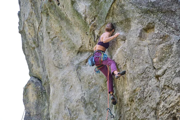 岩の多い山の急な壁を登る少女登山を決定した 難しいルートを克服するスポーツ女性 極端なスポーツやロッククライミングの趣味の概念に従事 — ストック写真