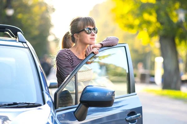 若い女性ドライバーは暖かい夏の日を楽しんで彼女の車の近くに休んでいます 旅行と休暇のコンセプト — ストック写真