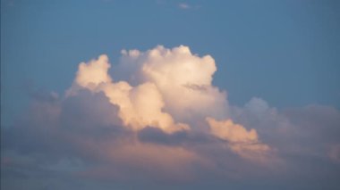 Mavi açık gökyüzünde hızlı hareket eden beyaz kabarık kümülüs bulutlarının hızlandırılmış görüntüleri.