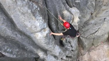 Kararlı dağcı kayalık dağın dik duvarından aşağı iniyor. Sporcu zor yolu aştı. Ekstrem sporlar ve kaya tırmanışı hobileri..