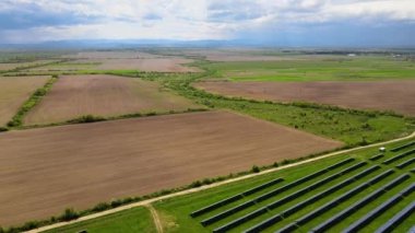 Temiz ekolojik elektrik enerjisi üretmek için birçok sıra güneş fotovoltaik paneli bulunan sürdürülebilir büyük elektrik santralinin havadan görünüşü. Sıfır emisyon kavramı ile yenilenebilir elektrik.