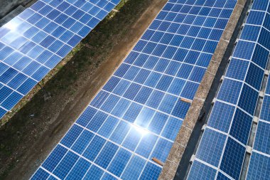Sanayi binasının çatısına yeşil ekolojik elektrik üretmek için monte edilmiş mavi fotovoltaik panelli güneş enerjisi santralinin hava görüntüsü. Sürdürülebilir enerji konsepti üretimi.