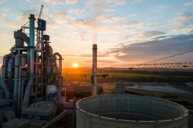 İnşaat halindeki çimento fabrikasının havadan görüntüsü yüksek beton yapı ve endüstriyel üretim alanında kule vinçleri var. Üretim ve küresel sanayi kavramı.