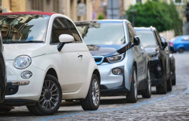 Sokak kenarında park halindeki arabalarla şehir trafiği.