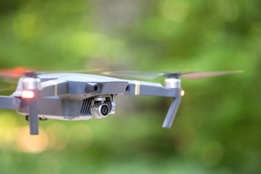 Hızla dönen pervaneleri ve havada uçuşan fotoğraf makinesi olan İHA uçakları..