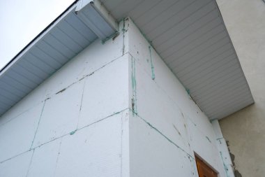 Termal koruma için ev cephesi duvarına köpük yalıtım çarşafları kurulumu.