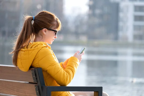 Jovem Mulher Bonita Sentada Banco Parque Navegando Seu Smartphone Livre — Fotografia de Stock