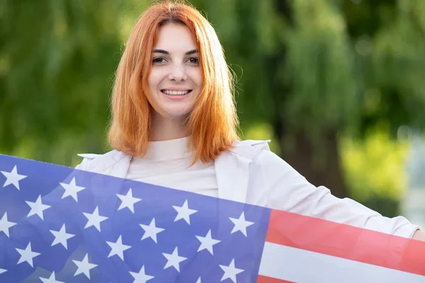 Portret Szczęśliwej Młodej Rudowłosej Kobiety Trzymającej Flagę Usa Rękach Stojącej — Zdjęcie stockowe