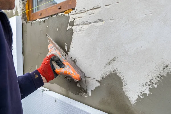 建筑工人用胶粘剂覆盖房屋墙壁 安装防热泡沫隔热板 — 图库照片