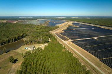 Temiz elektrik enerjisi üretmek için birçok sıra güneş fotovoltaik paneli bulunan sürdürülebilir büyük elektrik santralinin havadan görünüşü. Sıfır emisyon kavramı ile yenilenebilir elektrik.