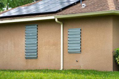 Kasırga panjurlu Florida evi fırtına güvenliği için pencereleri kapatmış. Beklenen doğal afetten önce koruyucu biniş.