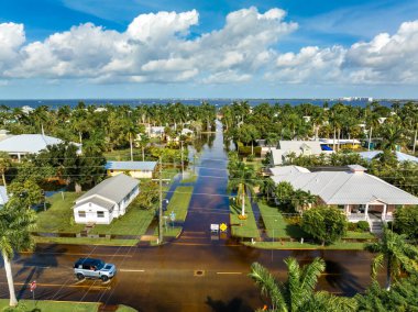 Su uyarı işaretinin altındaki yol. Şehir caddesi sel tehlikesi nedeniyle kapalı. Araba kullanmasını engelliyor..