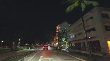 Ocean Drive 'da gece vakti Miami Beach, Florida' da araba kullanmak. Ulaşım ve trafik kavramı. İkonik seyahat hedefi