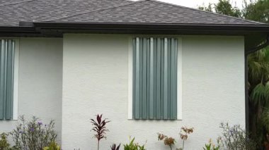 Kasırga koruması için güçlendirilmiş fırtına kepenkleri olan Florida 'daki bir ev. Felakete hazırlık olarak pencere örtüsü.