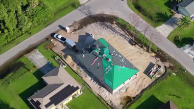 Çatı işçileri asfalt döşemeyi bitiriyor. Yeni ev yapım aşamasında. Konut geliştirme kavramı