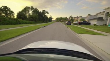 Araba sürücüsü. Ulaşım ve trafik kavramı. Florida yerleşim bölgesindeki evler arasında banliyö caddesinde araç sürüyor.