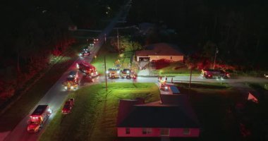 Firefighters investigating fire hazard on residential street in North Port in Florida. Bright flashing lights at night