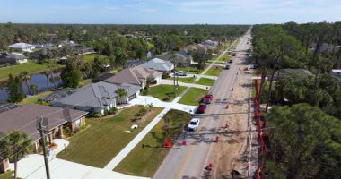 Florida caddesinde inşaat halindeki geçici trafik ışıkları ve koniler kapalı şeridi gösteriyor. İşçiler ve araçlar özel garaj yollarının yakınında.