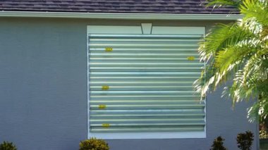 Kasırga koruması için güçlendirilmiş fırtına kepenkleri olan Florida 'daki bir ev. Felakete hazırlık olarak pencere örtüsü.