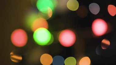 Renkli tatil ışıklarının soyut bokeh deseni yumuşak, parlak bir doku yaratıyor.