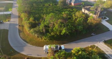 Çöp kamyonu banliyödeki çöp kutularını topluyor.