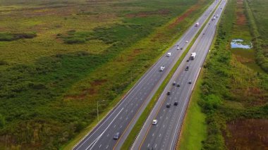 Florida 'daki Gainesville yakınlarında uzun düz otoban. Hızlı giden araçlar açık bataklık tarafından çevrelenmiş.