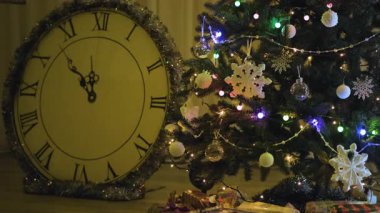 Geceleyin süslenmiş Noel ağacı dalları renkli süsler, çelenkler ve yanıp sönen ışık yansımaları samimi bir festival atmosferi yaratıyor.