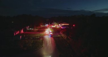 Firefighters investigating fire hazard on residential street in North Port in Florida. Bright flashing lights at night