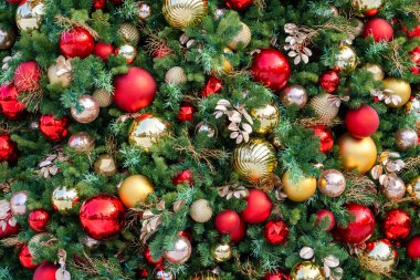 Noel ağacının yakın çekimi parlak mücevherler, renkli ışıklar ve ışıl ışıl dekorasyonların neşeli kış tatili ruhu yarattığını gösteriyor.