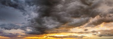Renkli sarı bulutlarla kaplı dramatik günbatımı gökyüzü. Panoramik gökyüzü.