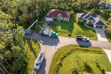 Elektrik işçileri Florida yerleşim bölgesindeki kasırga üstüne kova kamyonları kullanarak hasar görmüş elektrik hatlarını onarıyor..