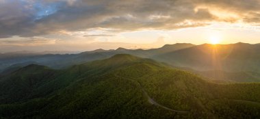 Yaz akşamları yeşil tepe örtüleri olan dağ ormanlarında dolambaçlı bir yol. Yazın Kuzey Carolina 'da vahşi orman doğasında araba sürmek.