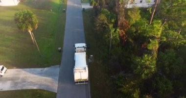 Otomatik modern çöp kamyonu Florida şehir caddesinde atık yüklüyor. Belediye hizmetleri