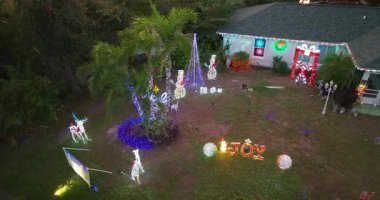 Florida avlusunda parlak yeni yıl ışıkları ve süslemeleri. Noel süsleri kış akşamının sıcaklığında parlıyor.