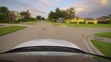 Araba sürücüsü. Ulaşım ve trafik kavramı. Florida yerleşim bölgesindeki evler arasında banliyö caddesinde araç sürüyor.