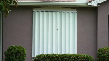 Kasırganın ev pencerelerini koruması için çelik çarşaflar, fırtına kepenkleri olarak monte edildi. Florida 'daki doğal felaketten önce koruyucu tedbirler.