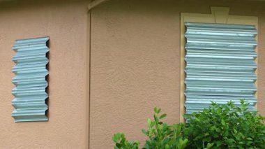 Fırtınaya dayanıklı çelik panjurlar, kasırgadan önce önlem olarak Florida 'daki evin camlarını kapatır. Ev aşırı havaya hazır..