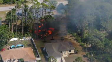 Florida 'daki yerleşim yerlerinin yakınlarındaki orman yangınlarında duman yükseliyor ve mülke yakın yerlerde alevler görülüyor..