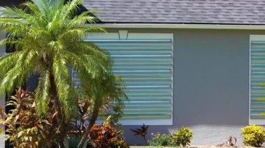 Kasırgalara karşı korunmak için Florida 'daki yerleşim yerlerinin camlarına metal fırtına kepenkleri takıldı. Doğal afetten önce önleyici güvenlik önlemi.