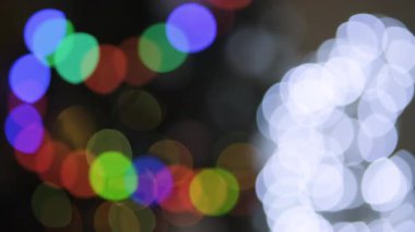 Altın ve kırmızı Noel ışıklarından oluşan yumuşak, ışıldayan bokeh sıcak, neşeli bir zemin oluşturuyor.